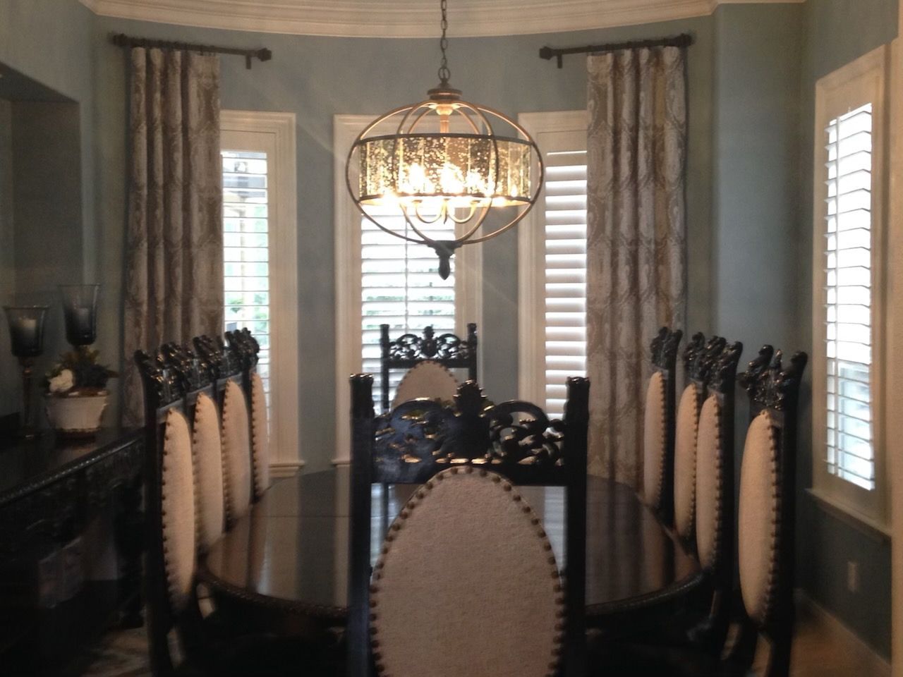 A dining room with a table and chairs and a chandelier