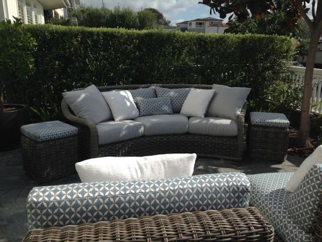 A patio with wicker furniture and a curved couch
