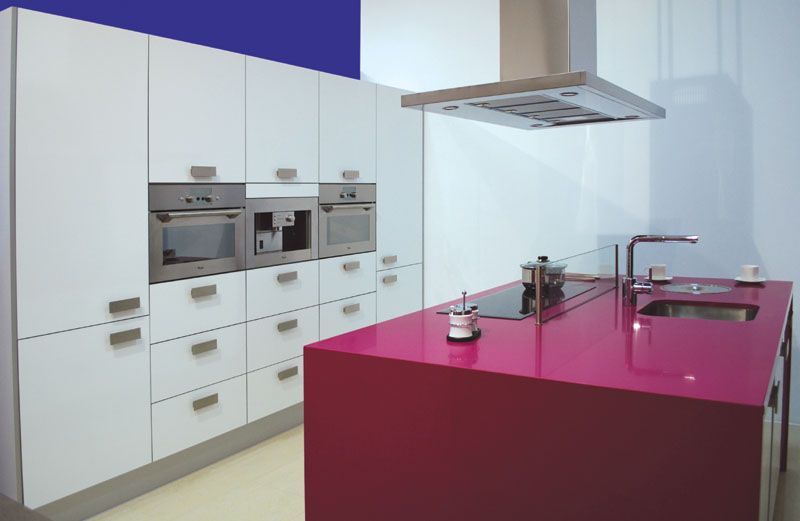 Cocina moderna con gabinetes blancos y una isla de color rosa brillante.
