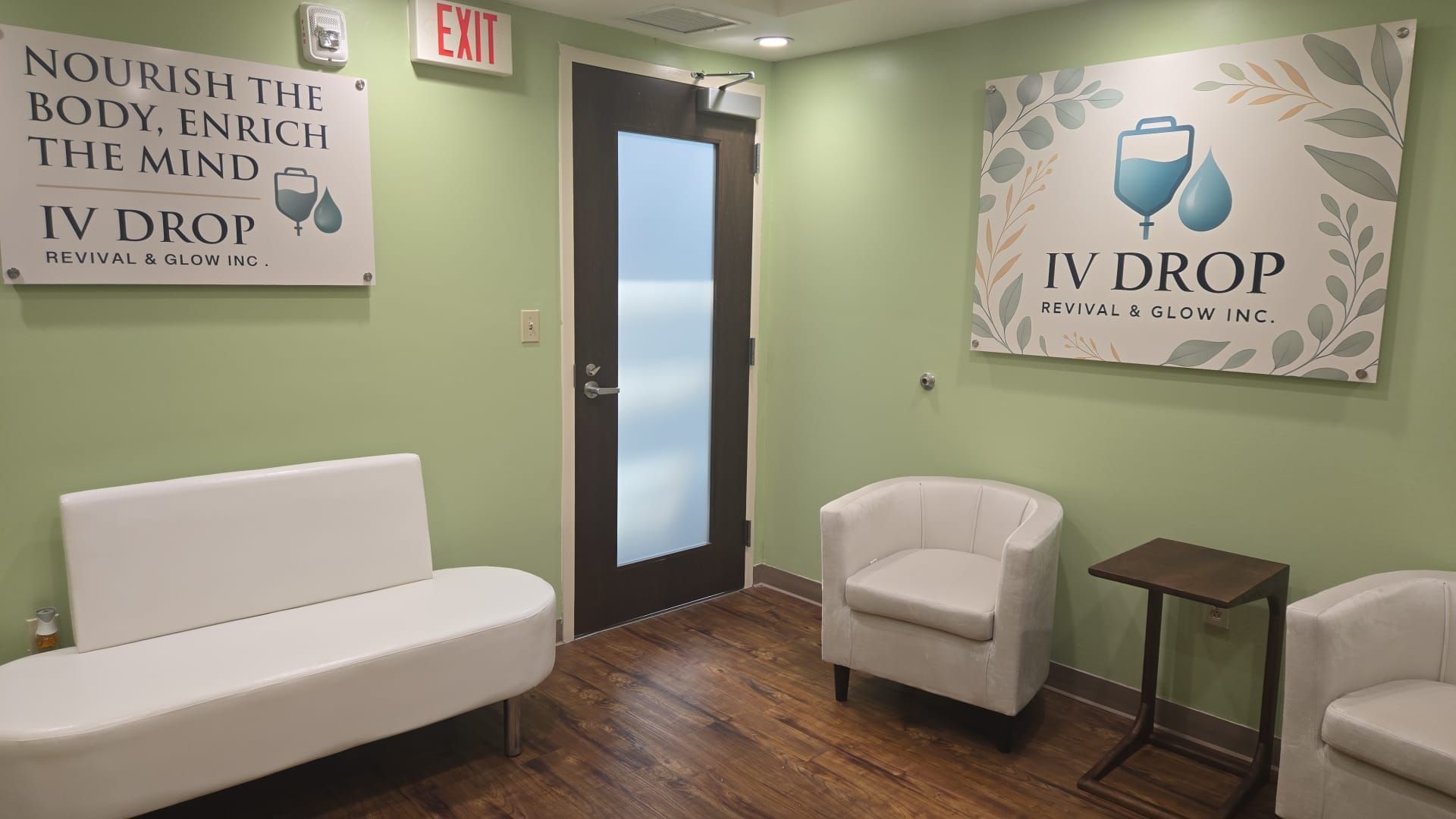 Waiting room with white furniture, green walls, and IV Drop logo.
