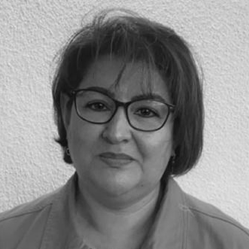 A black and white photo of a woman wearing glasses.