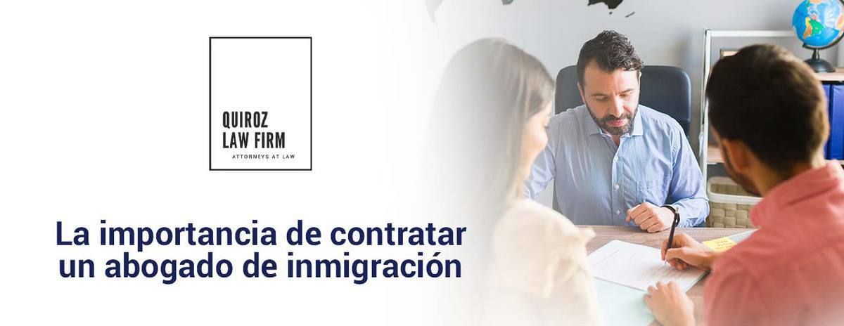 A man and a woman are sitting at a table with a sign that says la importancia de contratar un abogado de inmigracion