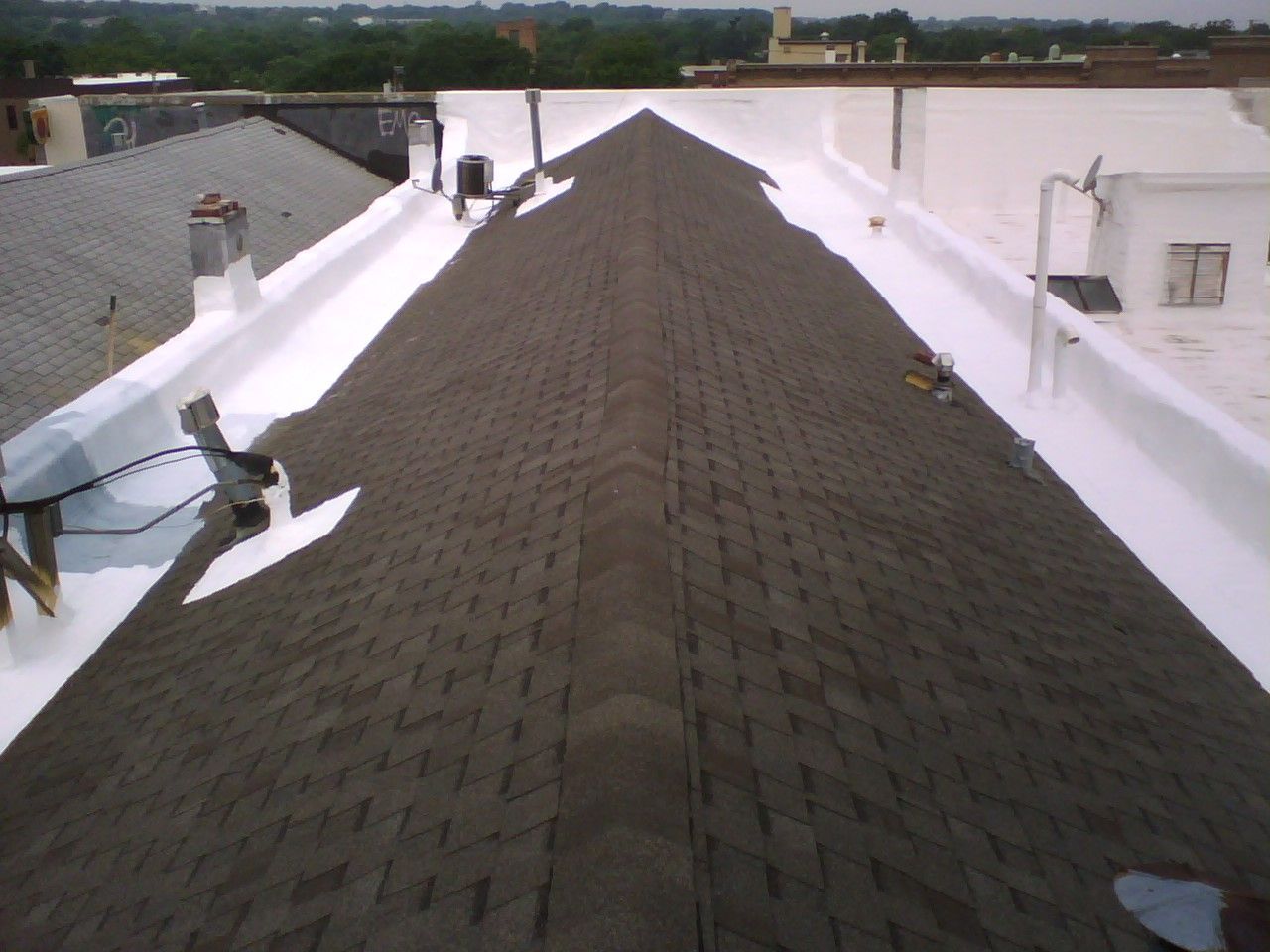 A roof with shingles and a white gutter