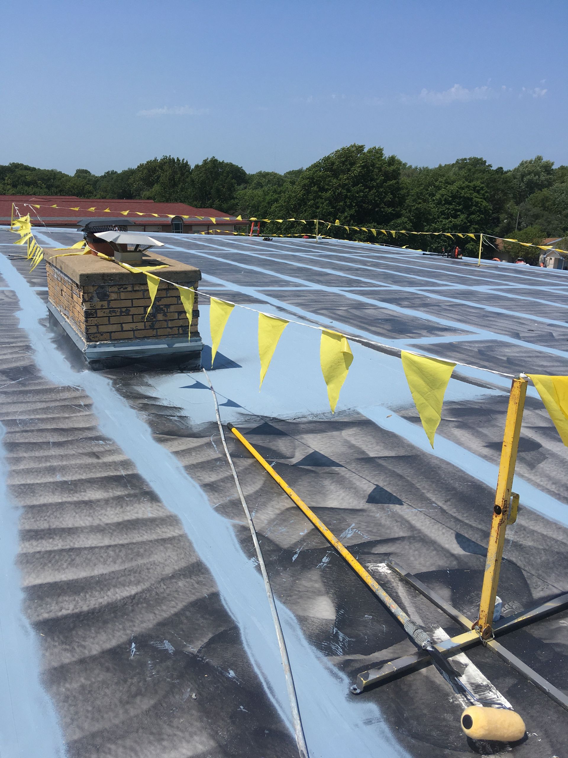 A roof with a chimney and yellow flags on it