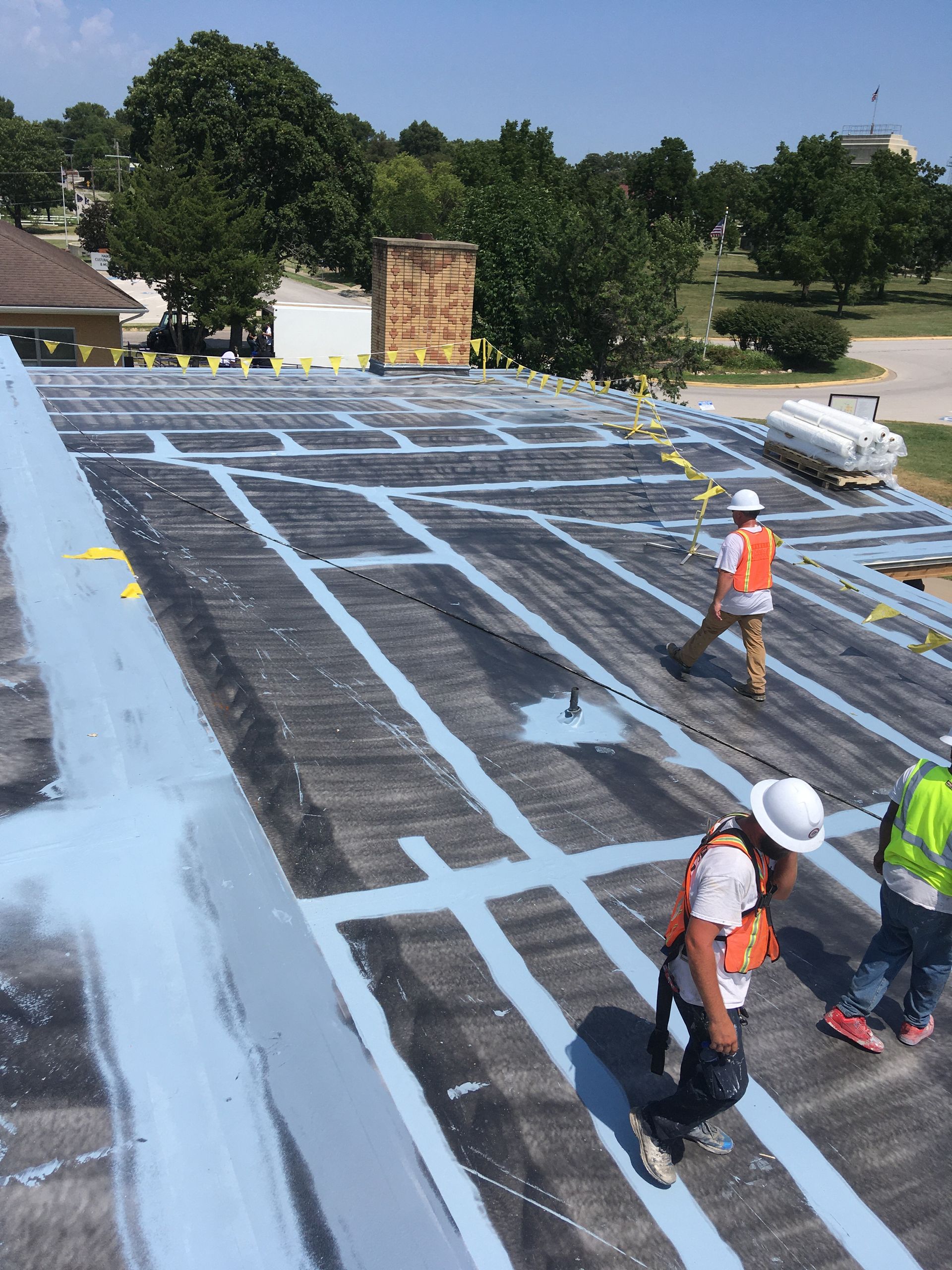 A group of construction workers are working on a roof.