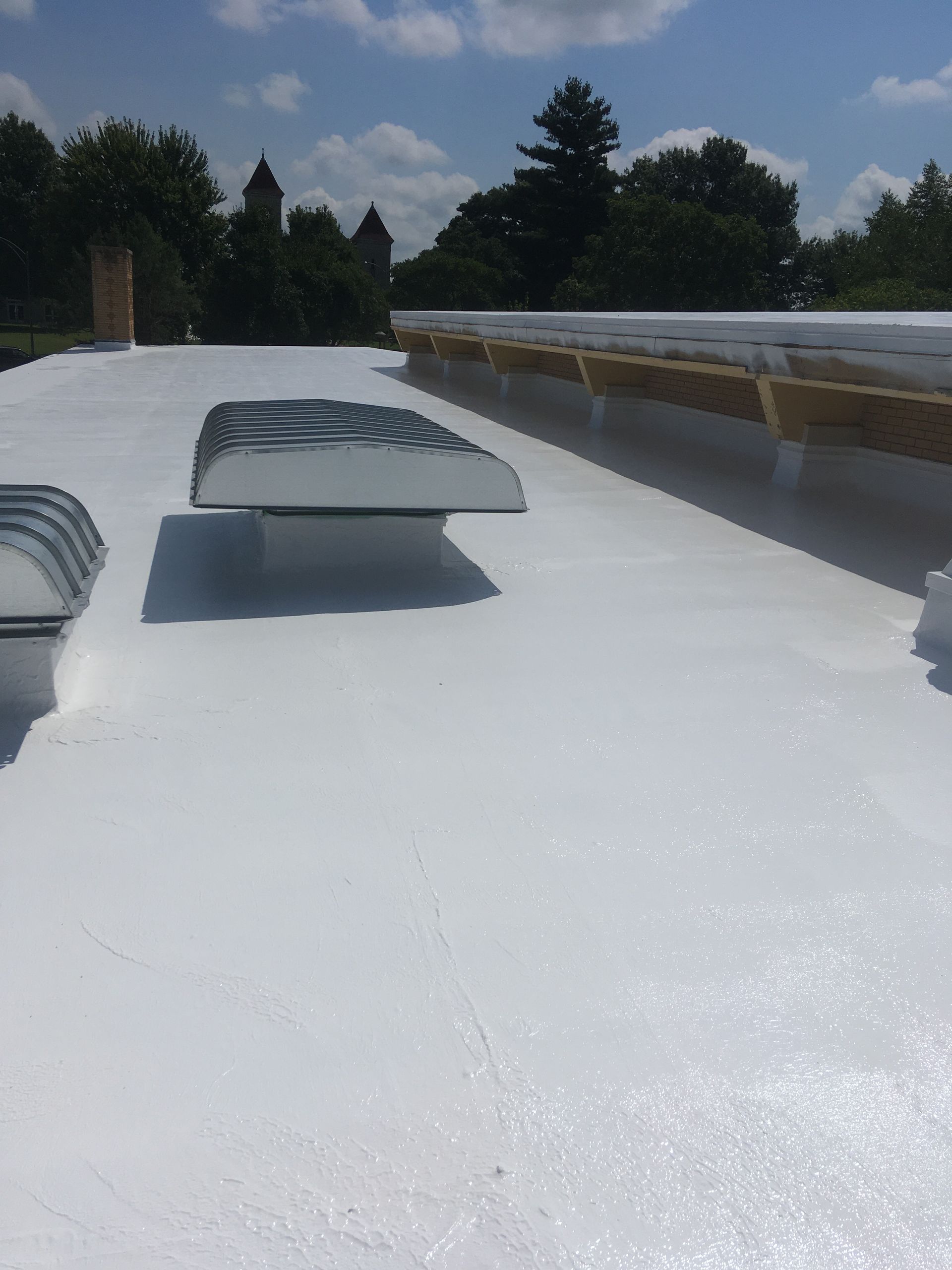 A white roof with a chimney on top of it