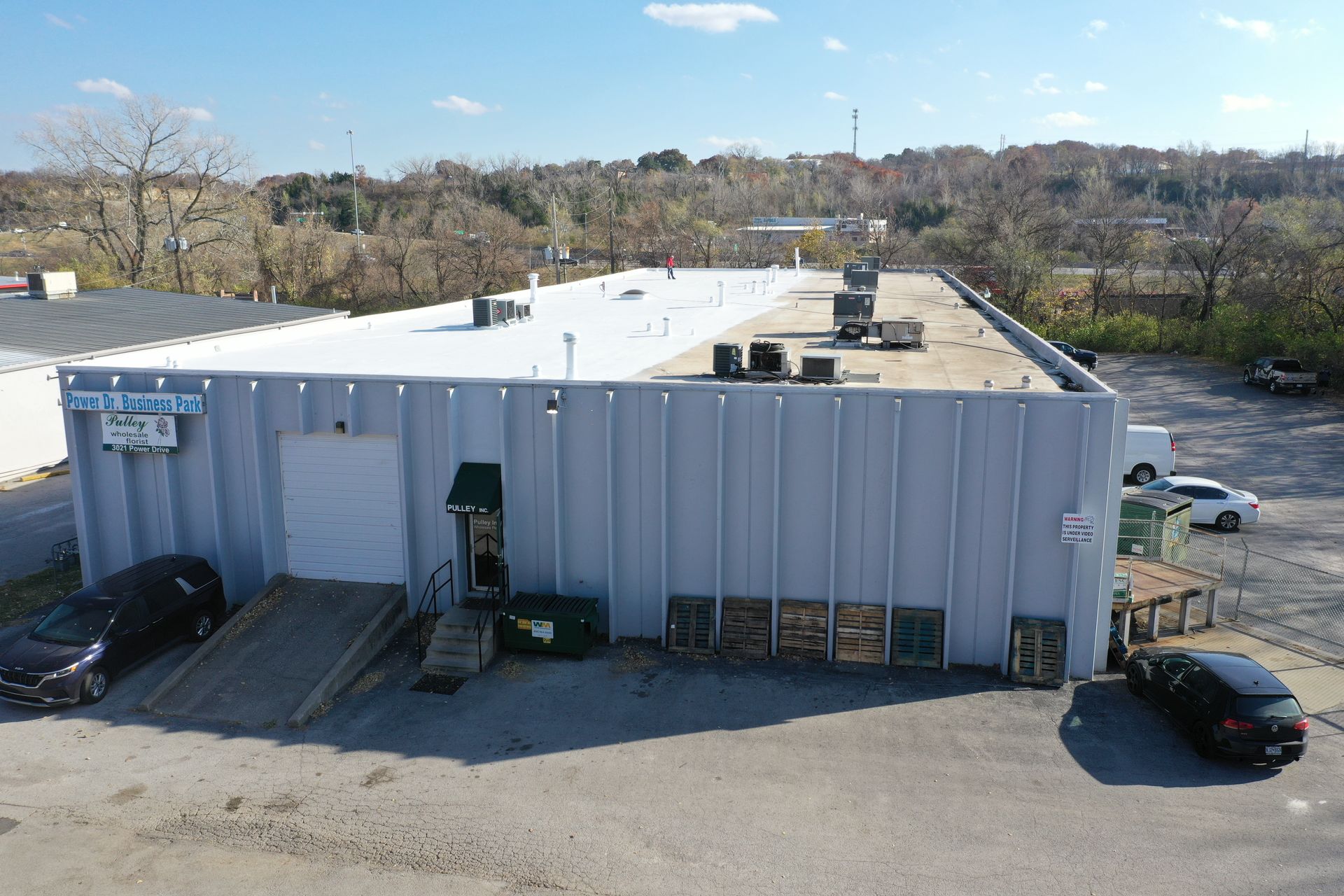 An aerial view of a large white building with a white roof.