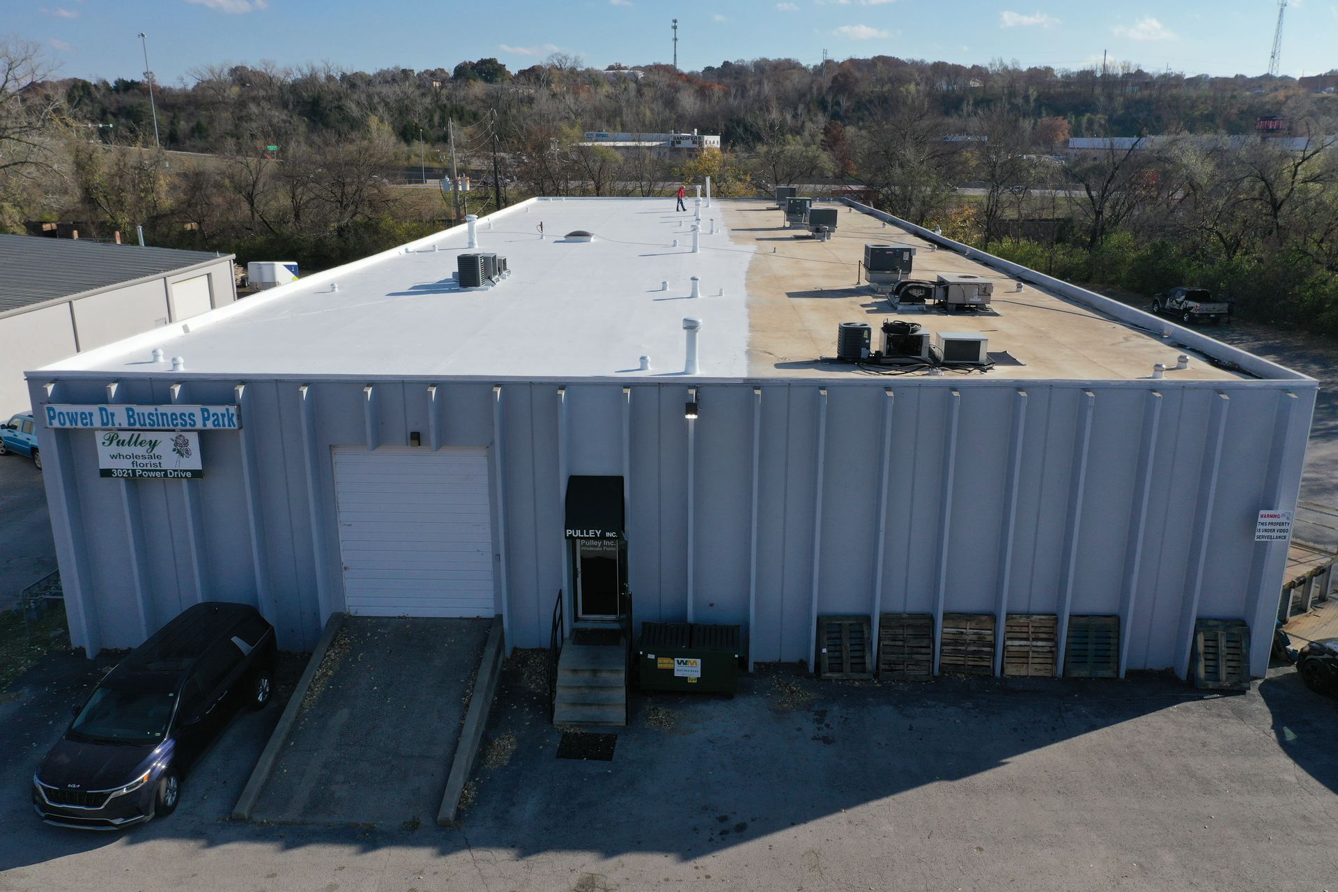 An aerial view of a large building with a white roof.