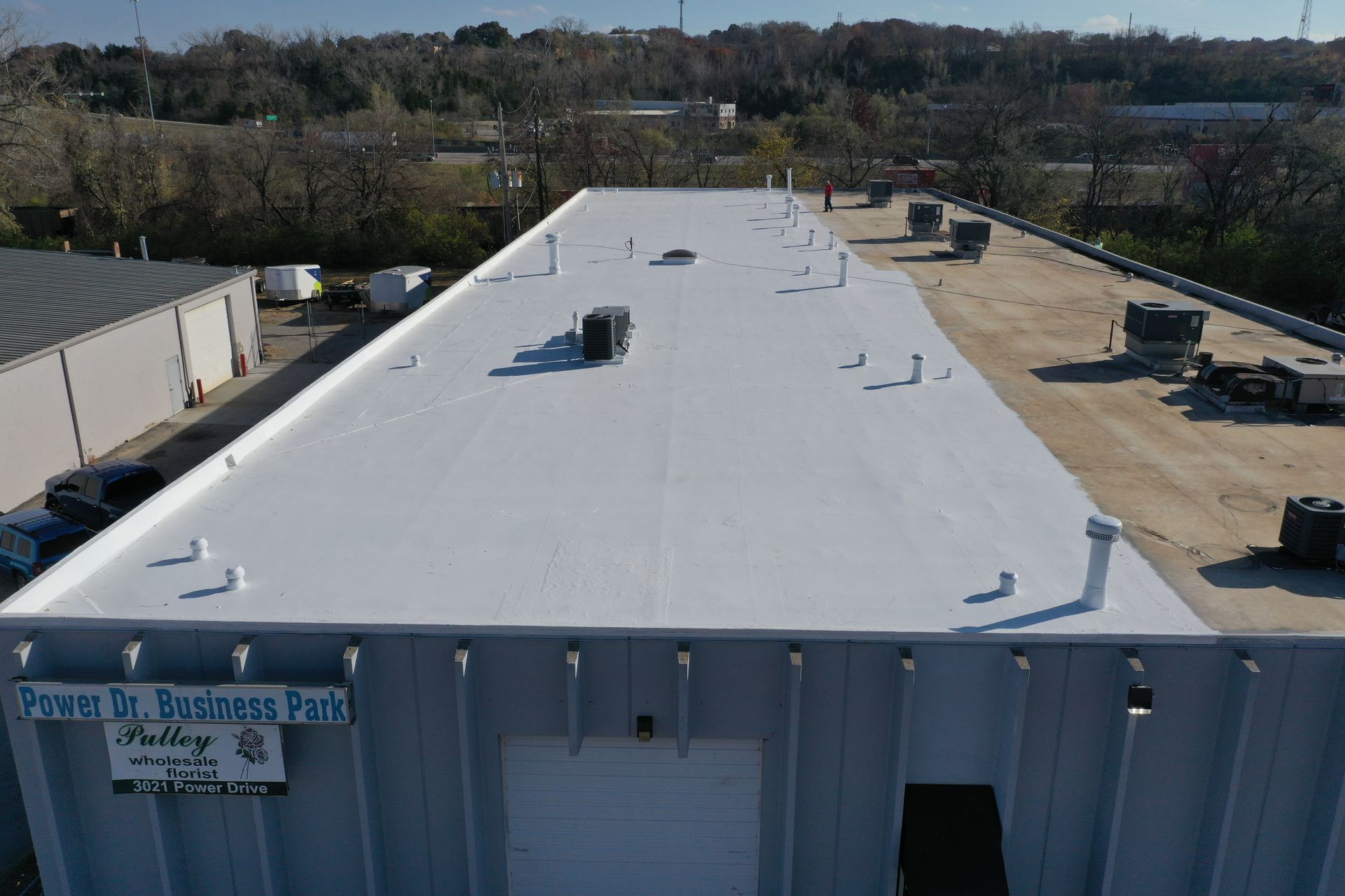 An aerial view of a large building with a white roof.
