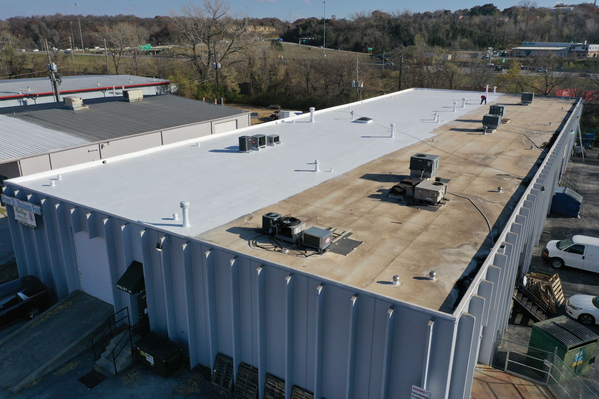 An aerial view of a large building with a white roof.