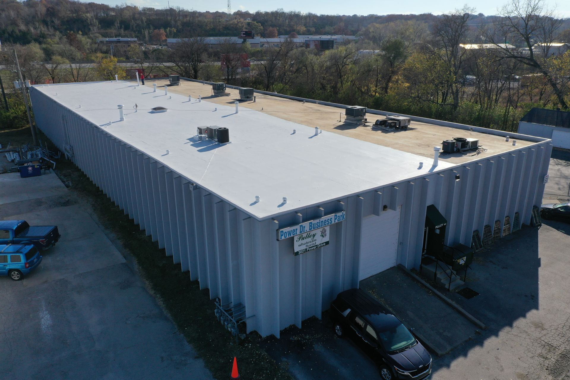 An aerial view of a large building with a white roof.