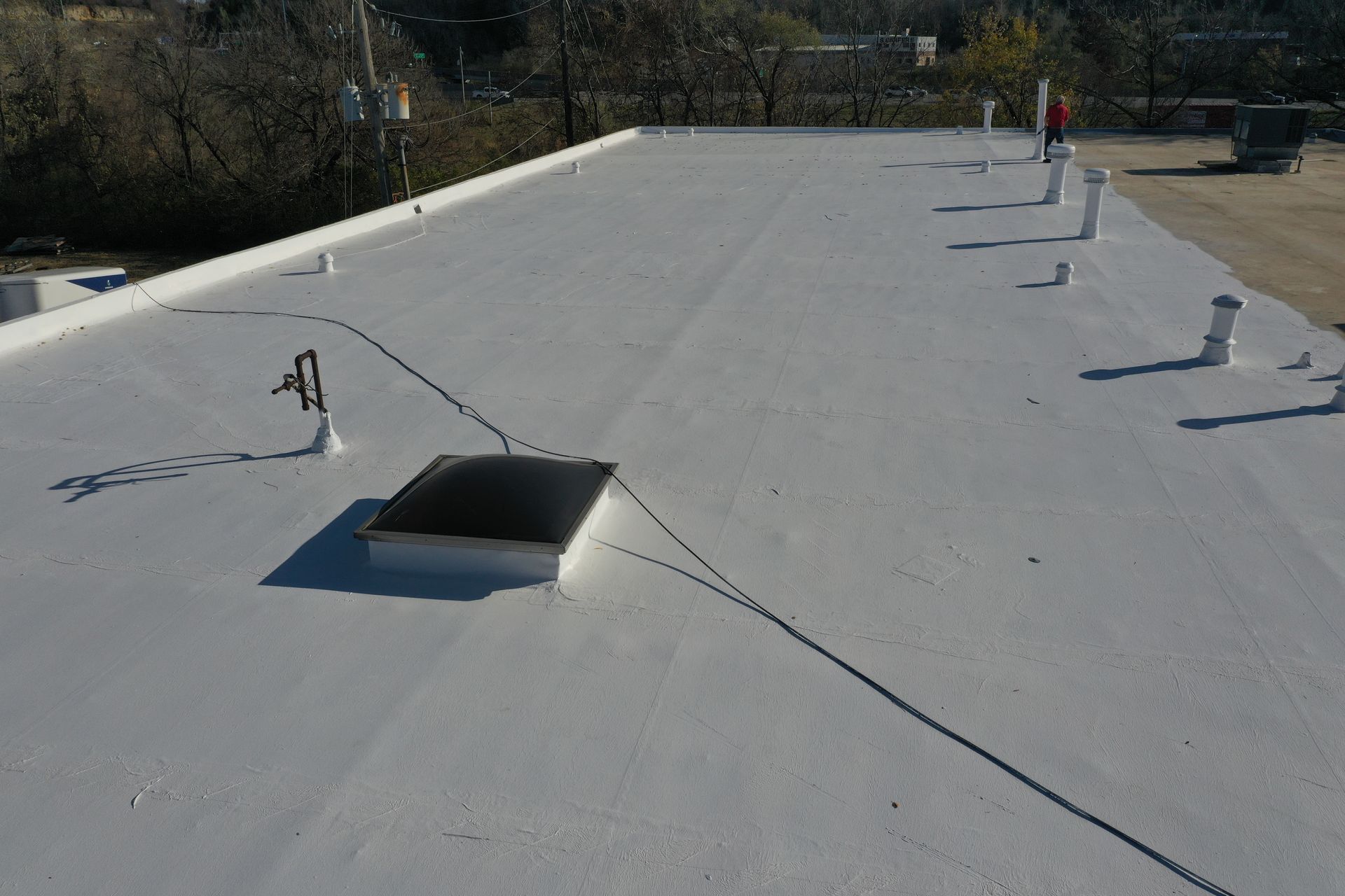 A white roof with a skylight and a rope attached to it.