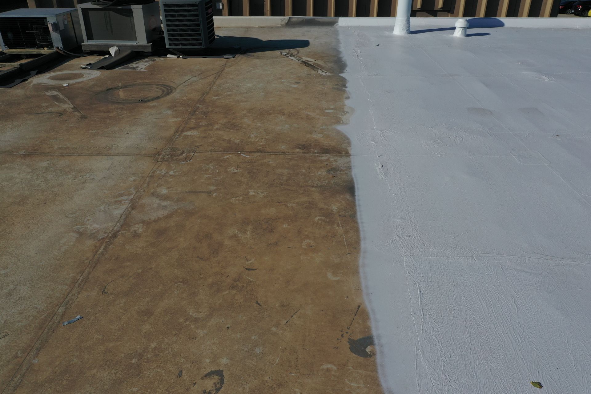 A roof with a white coating being applied to it.