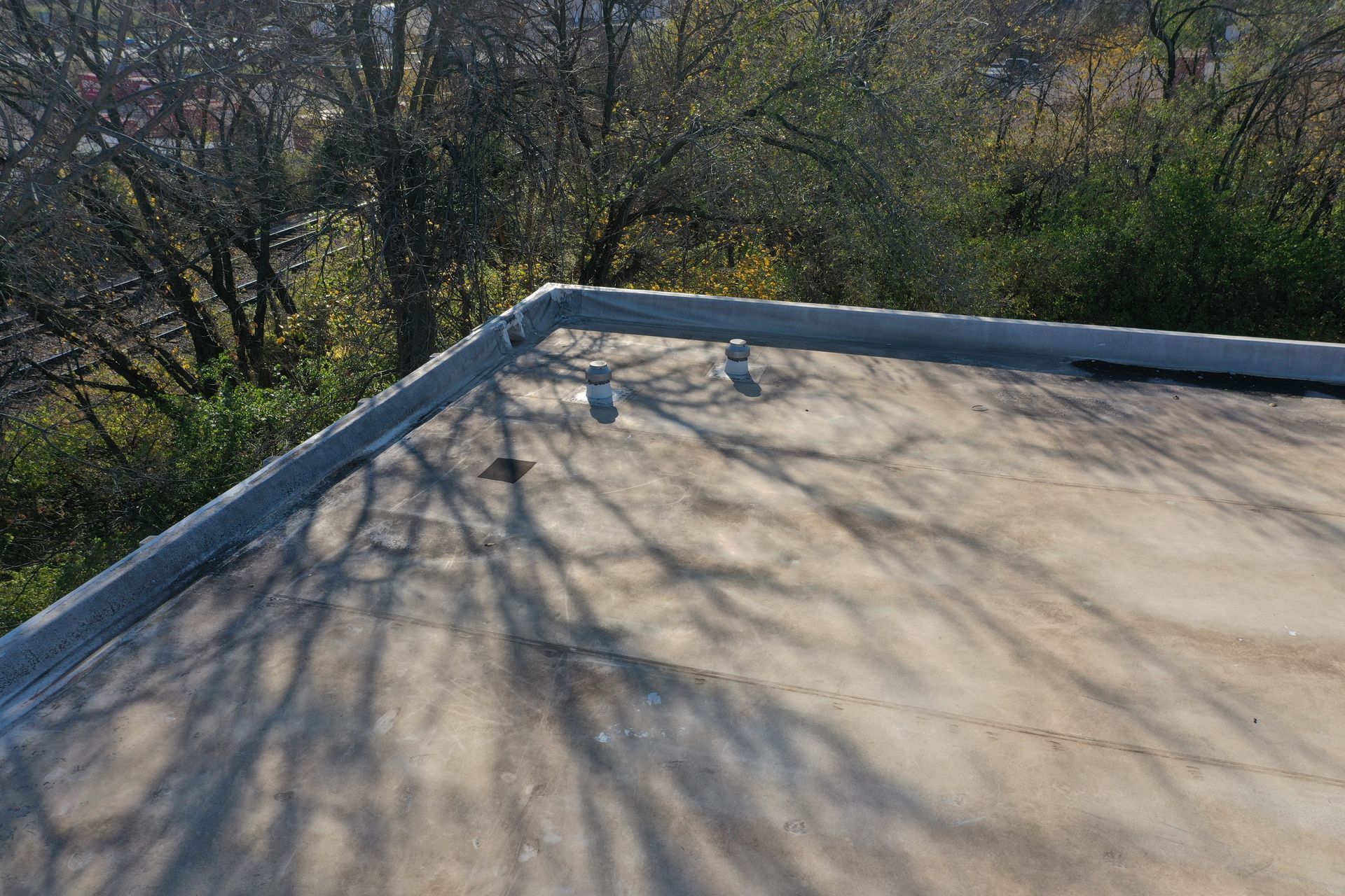 A close up of a roof with trees in the background.