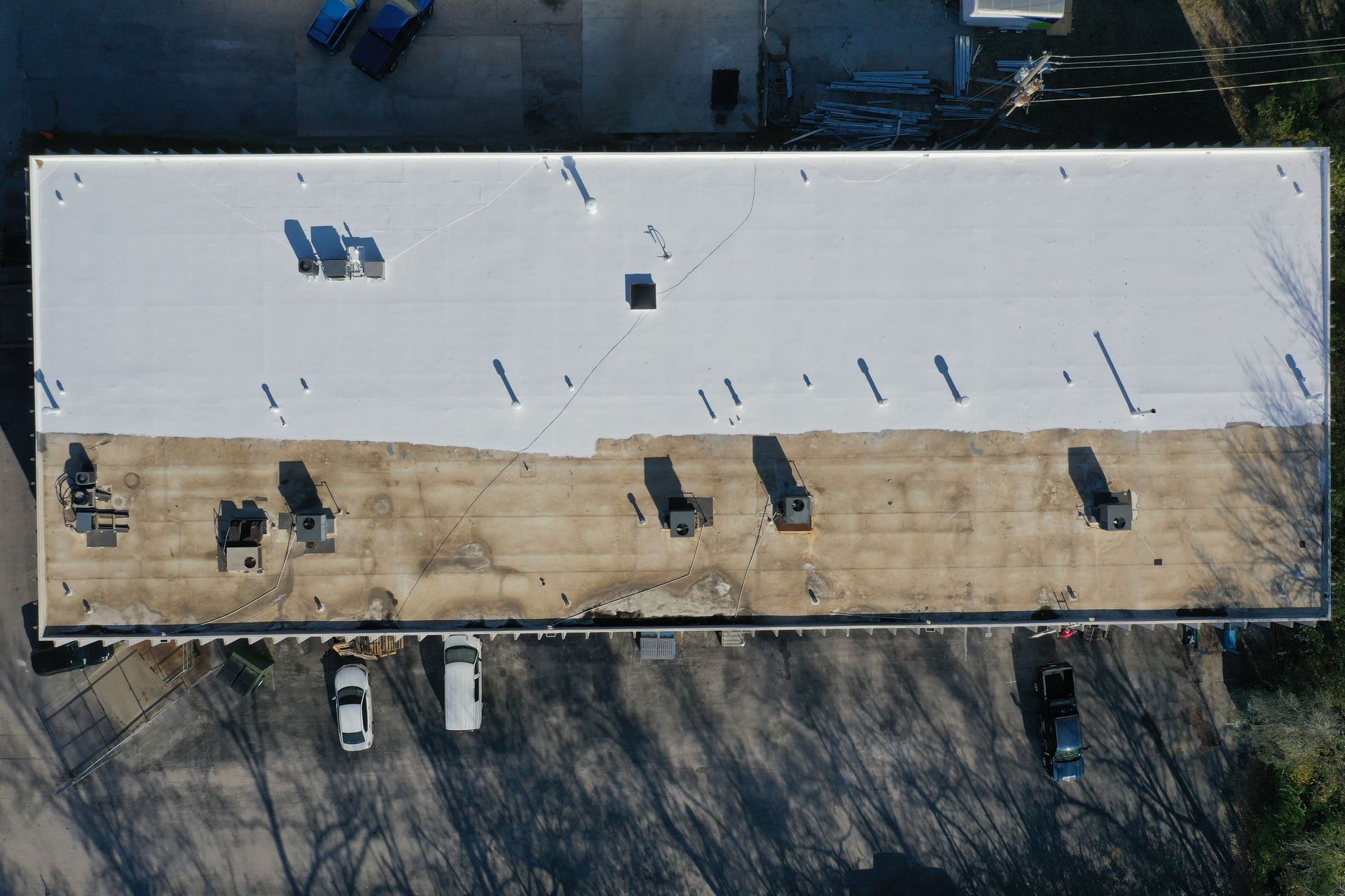 An aerial view of a large building with a white roof.