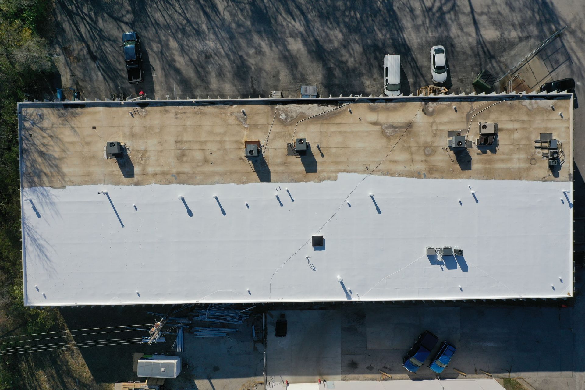 An aerial view of a large building with a white roof.