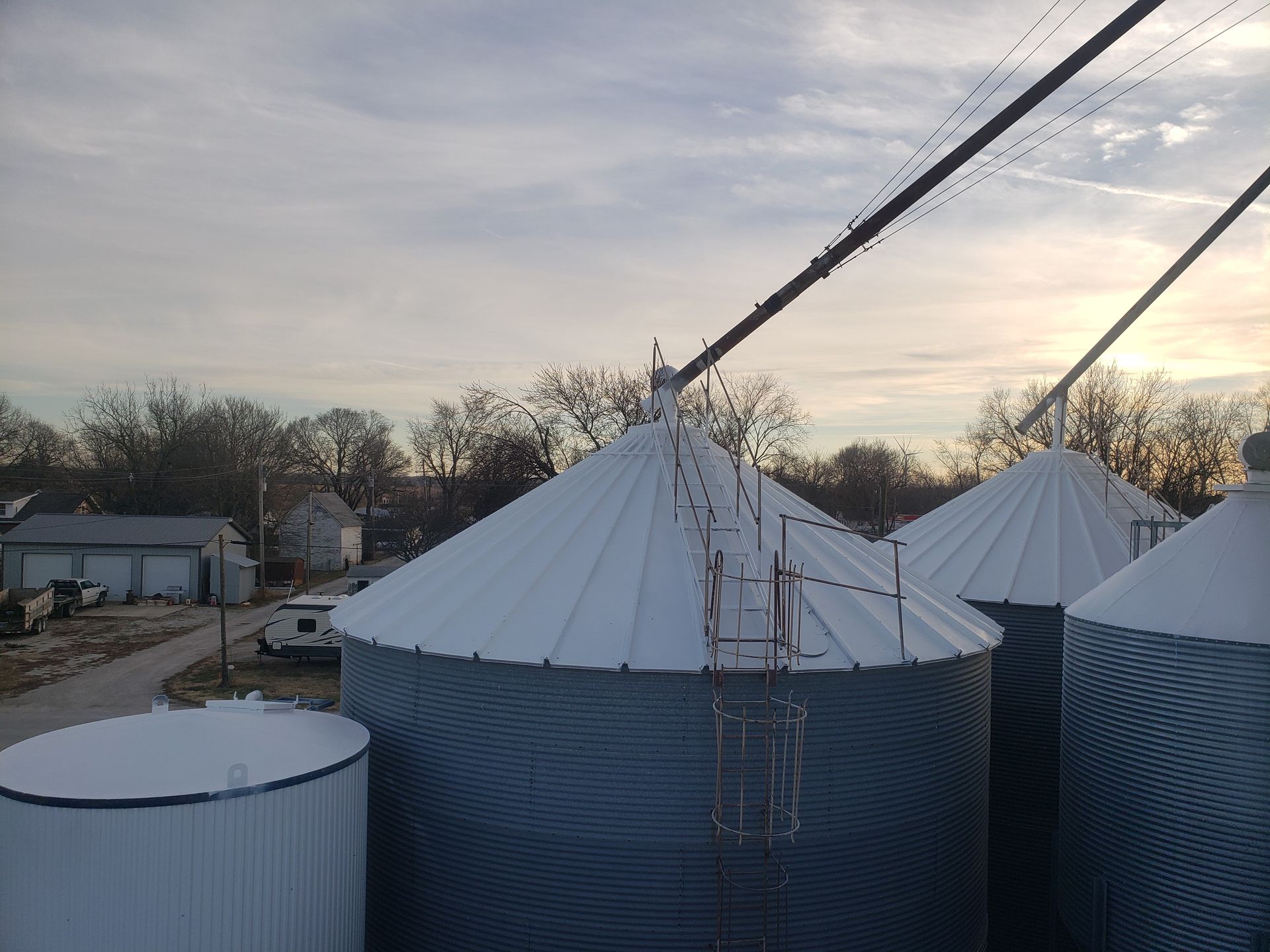 A row of silos covered in snow with a ladder leading up to them.