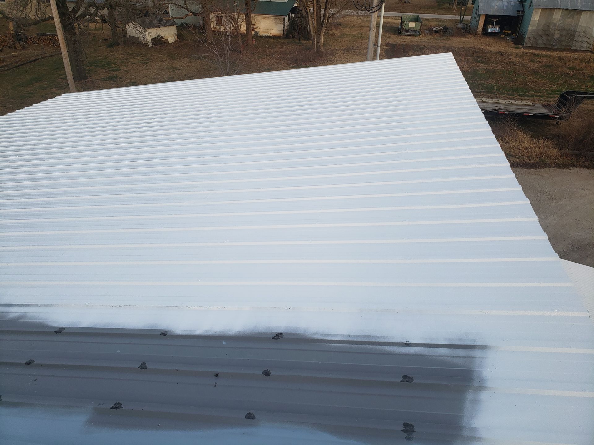 The roof of a building is being painted white.