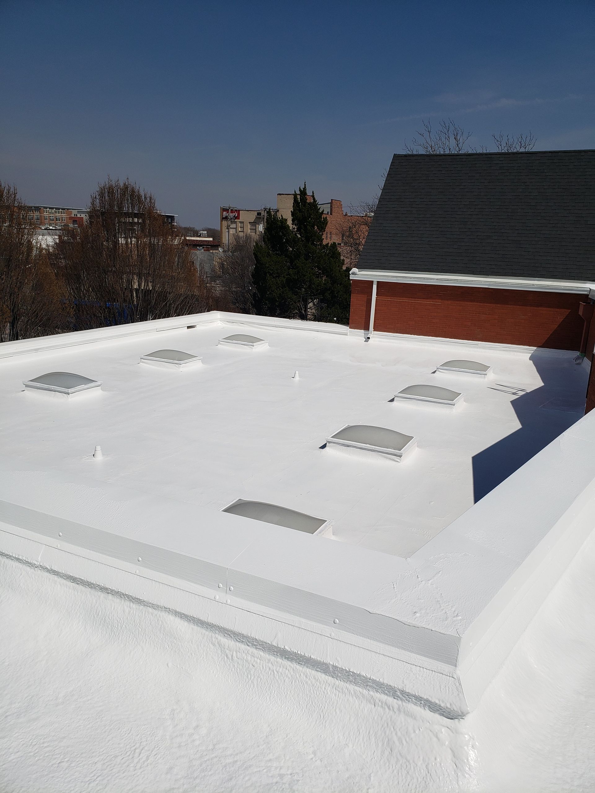 A white roof with a brick building in the background