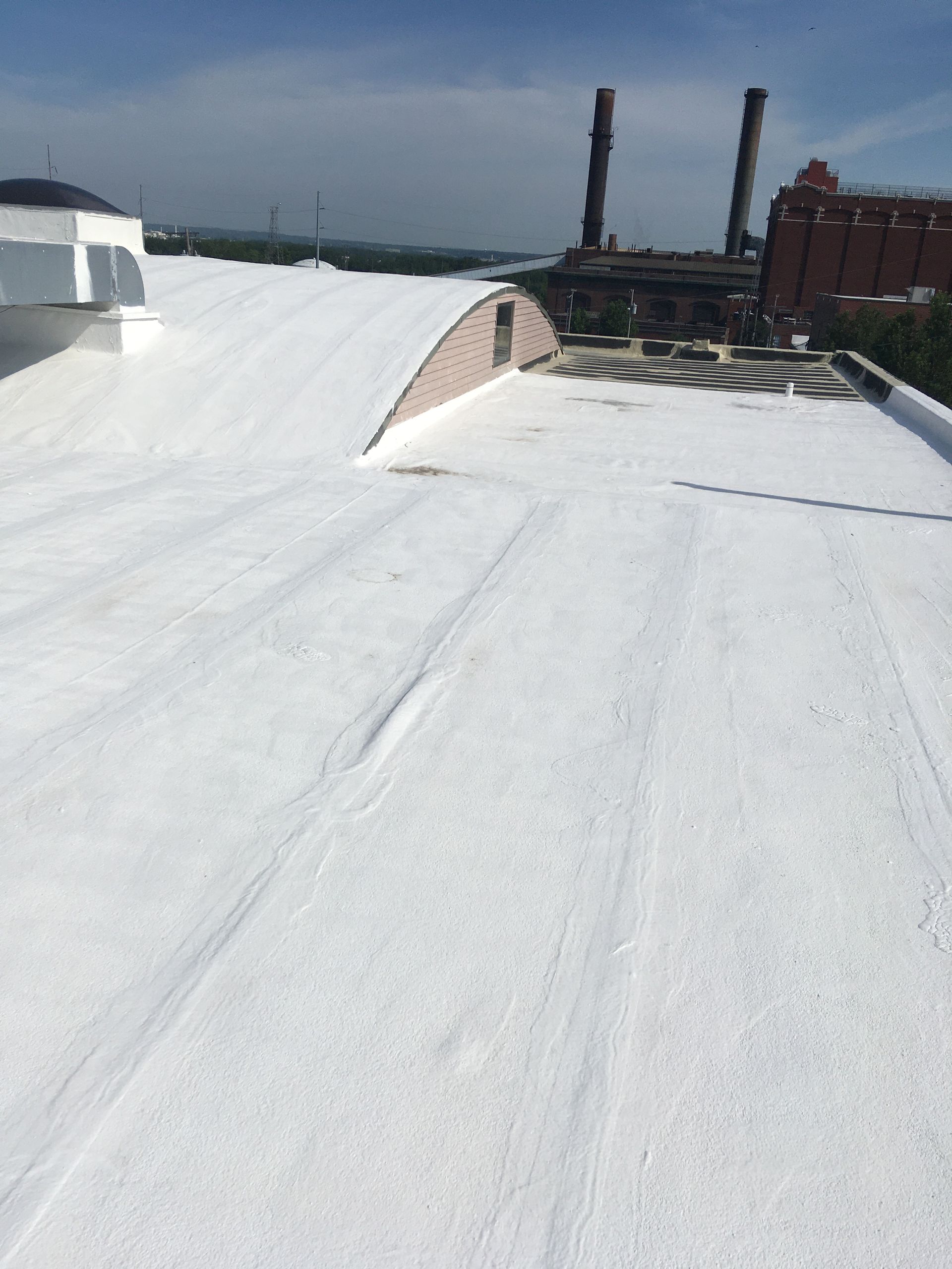 A white roof with a factory in the background