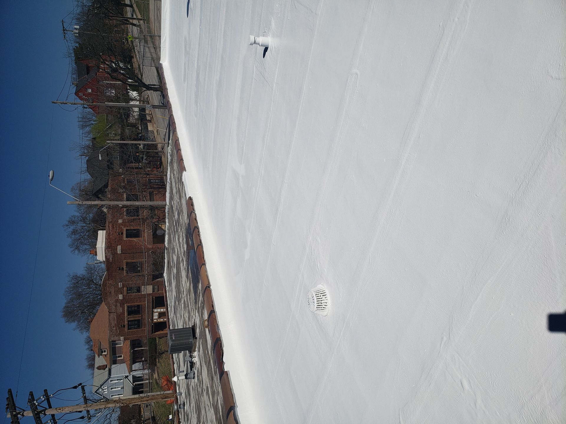 A white roof with a drain hole in the middle of it.