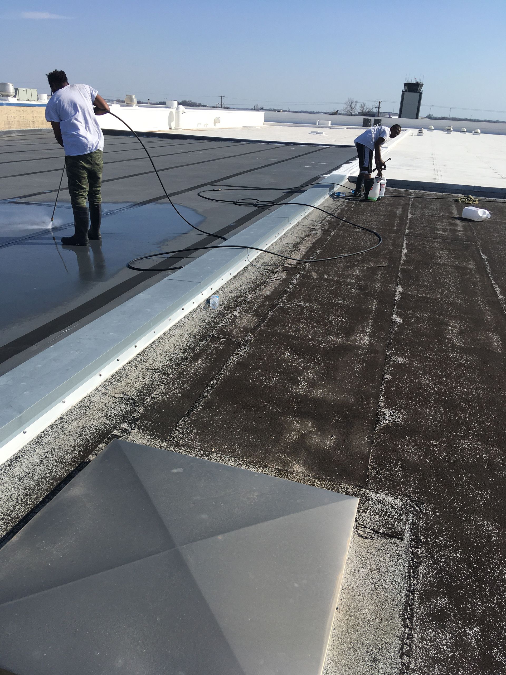Two men are working on the roof of a building.