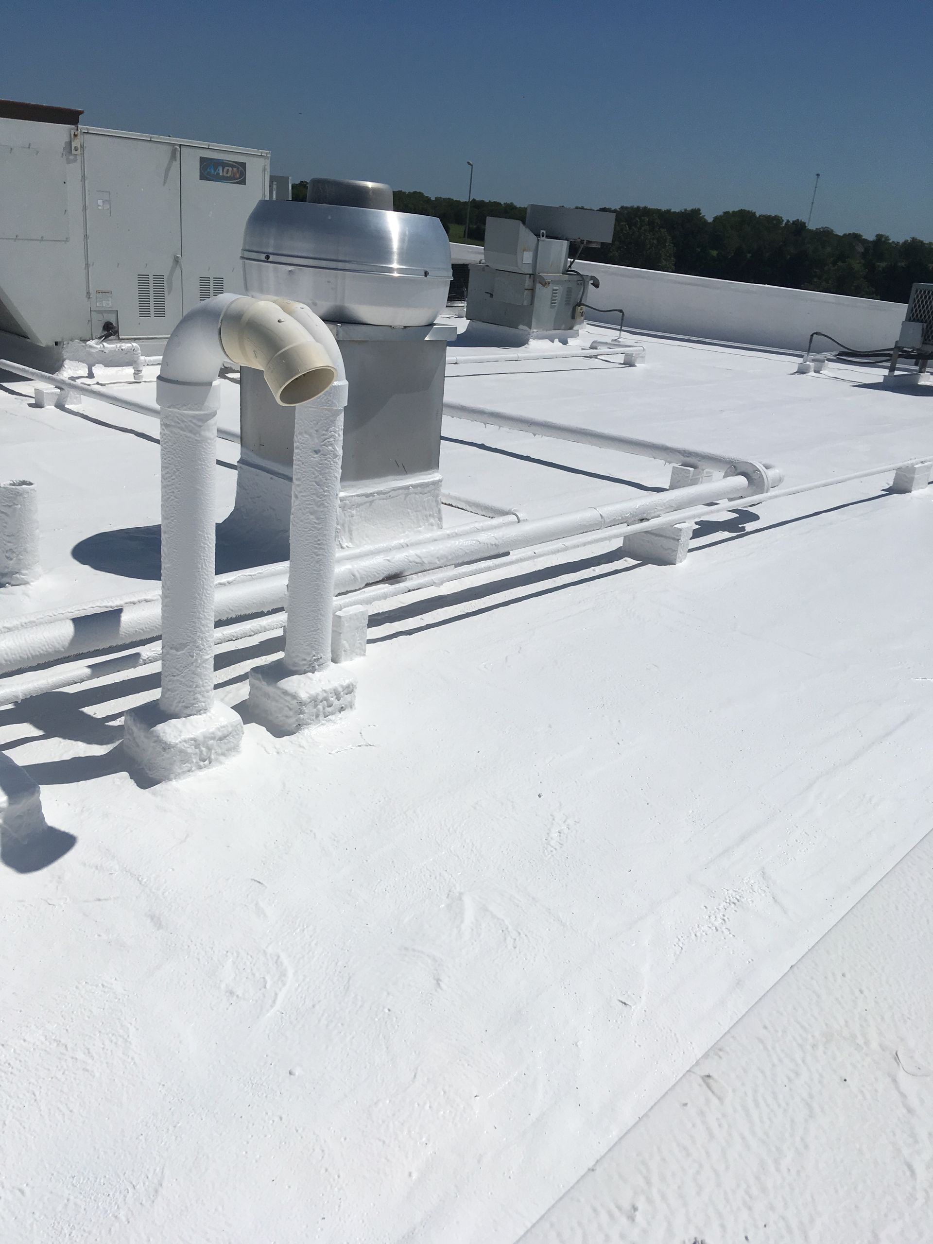 A white roof with a lot of pipes on it
