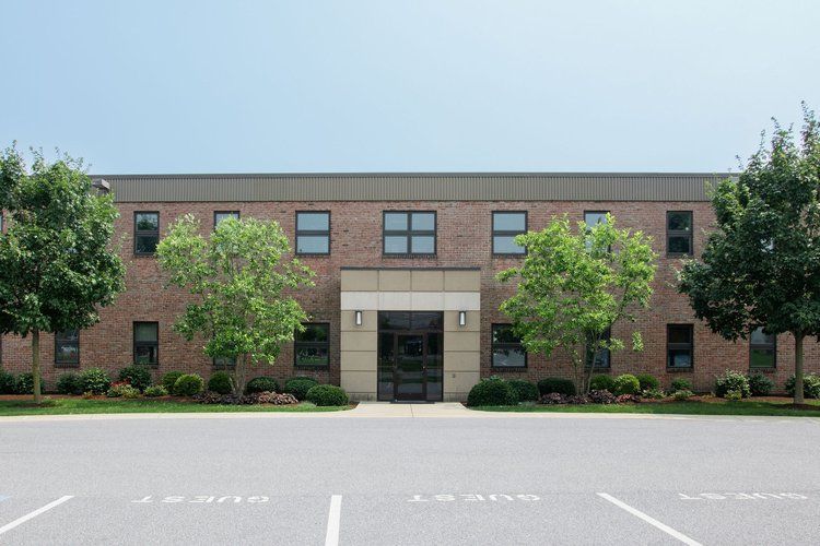 A large brick building with a parking lot in front of it