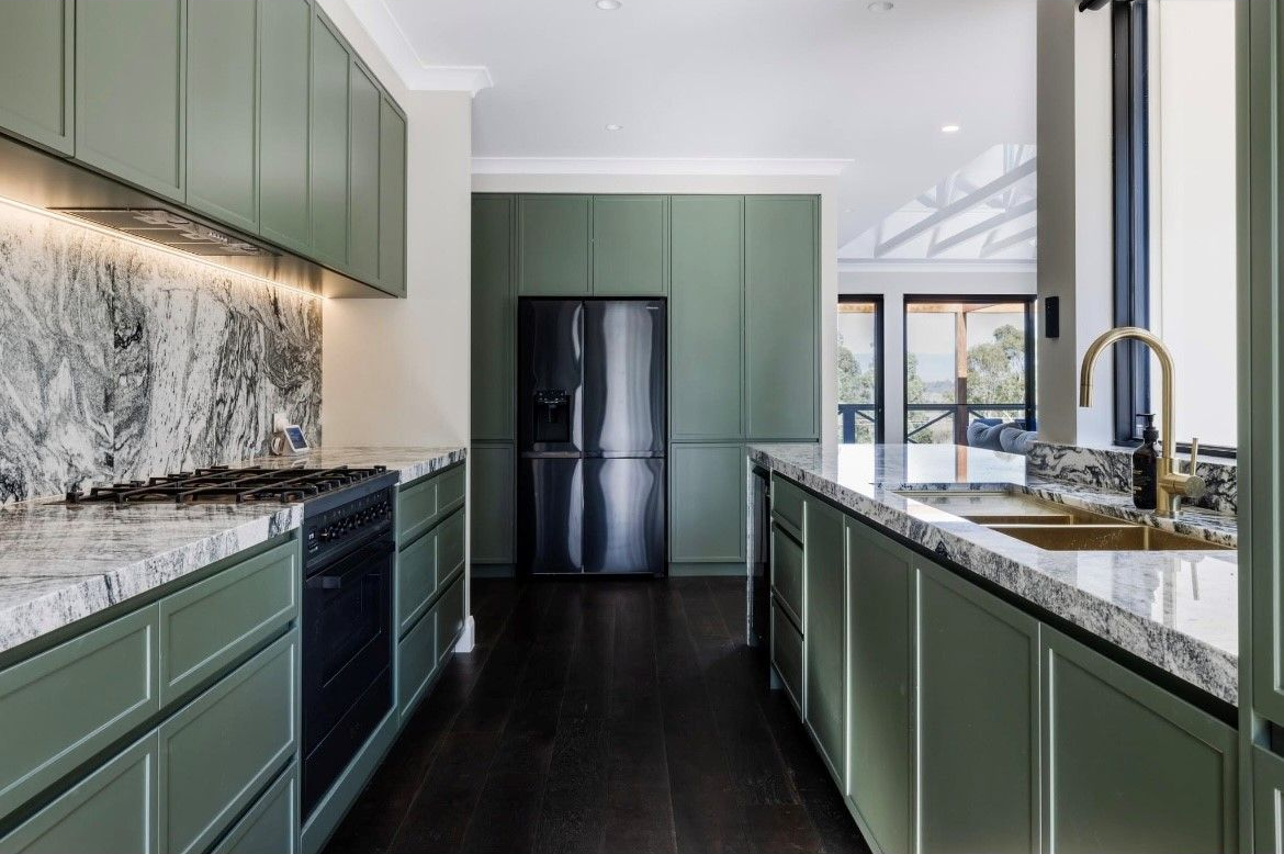 A Kitchen with Black Cabinets and Wooden Cabinets and A Stove Top Oven — Inovative Interiors In Card