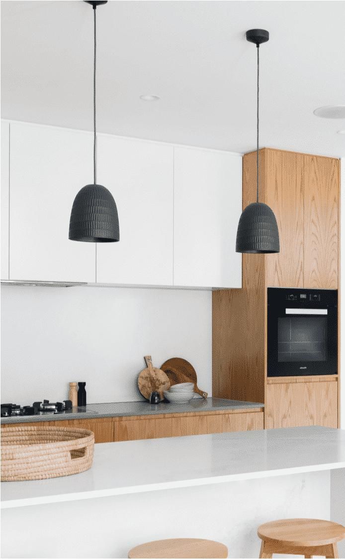 A Kitchen with White Cabinets and Wooden Cabinets and Stools — Inovative Interiors In Cardiff, NSW