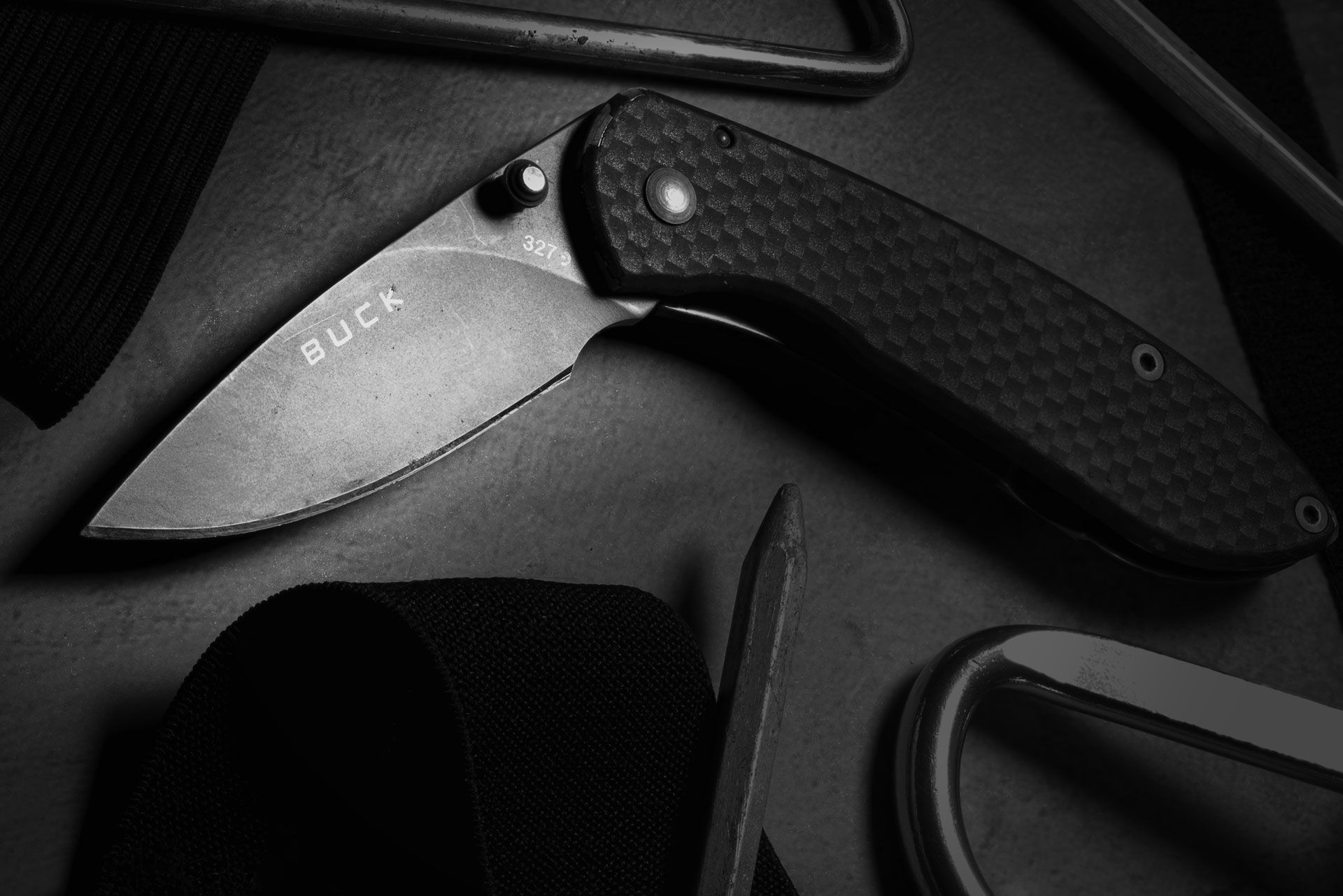 Buck pocket knife with a textured handle on a dark surface.