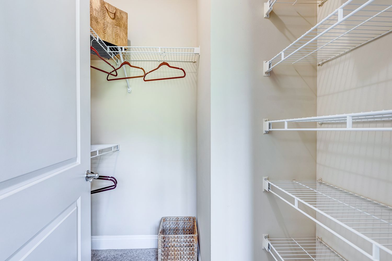 Closet interior with wire shelving and hangers, white and neutral tones at Arcadia's Edge in Columbia, SC.