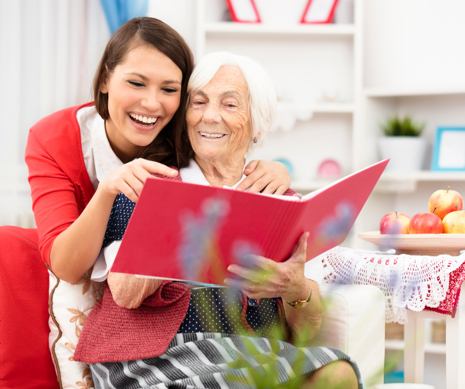 Elderly patient reading a book with caregivers assistance