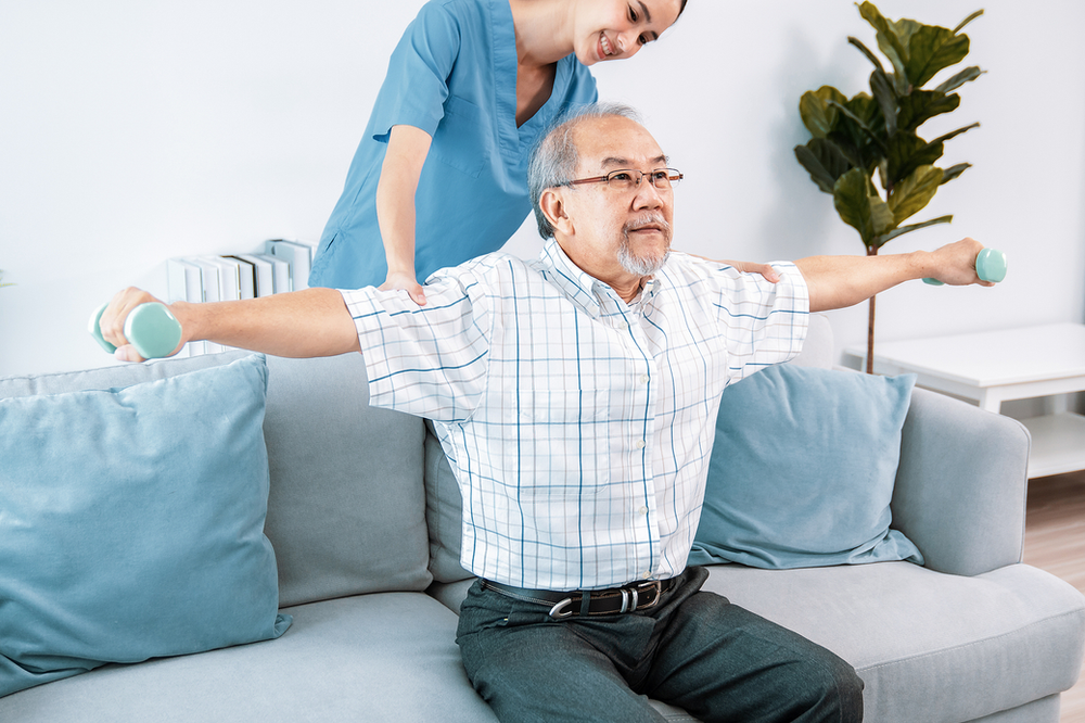 Senior citizen exercising with therapists help