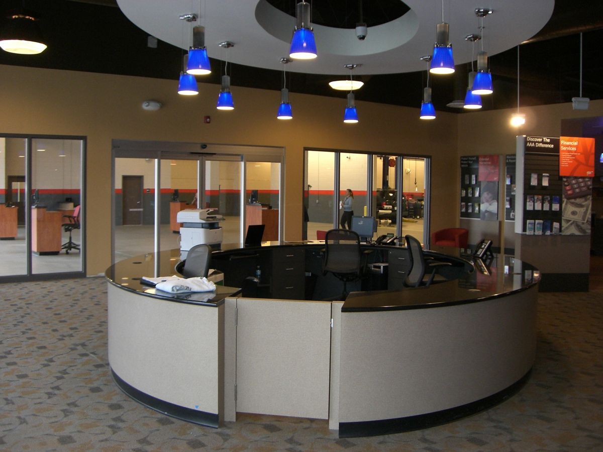 Indoor swimming pool with lanes, starting blocks, and red and black pennant flags hanging above the water.