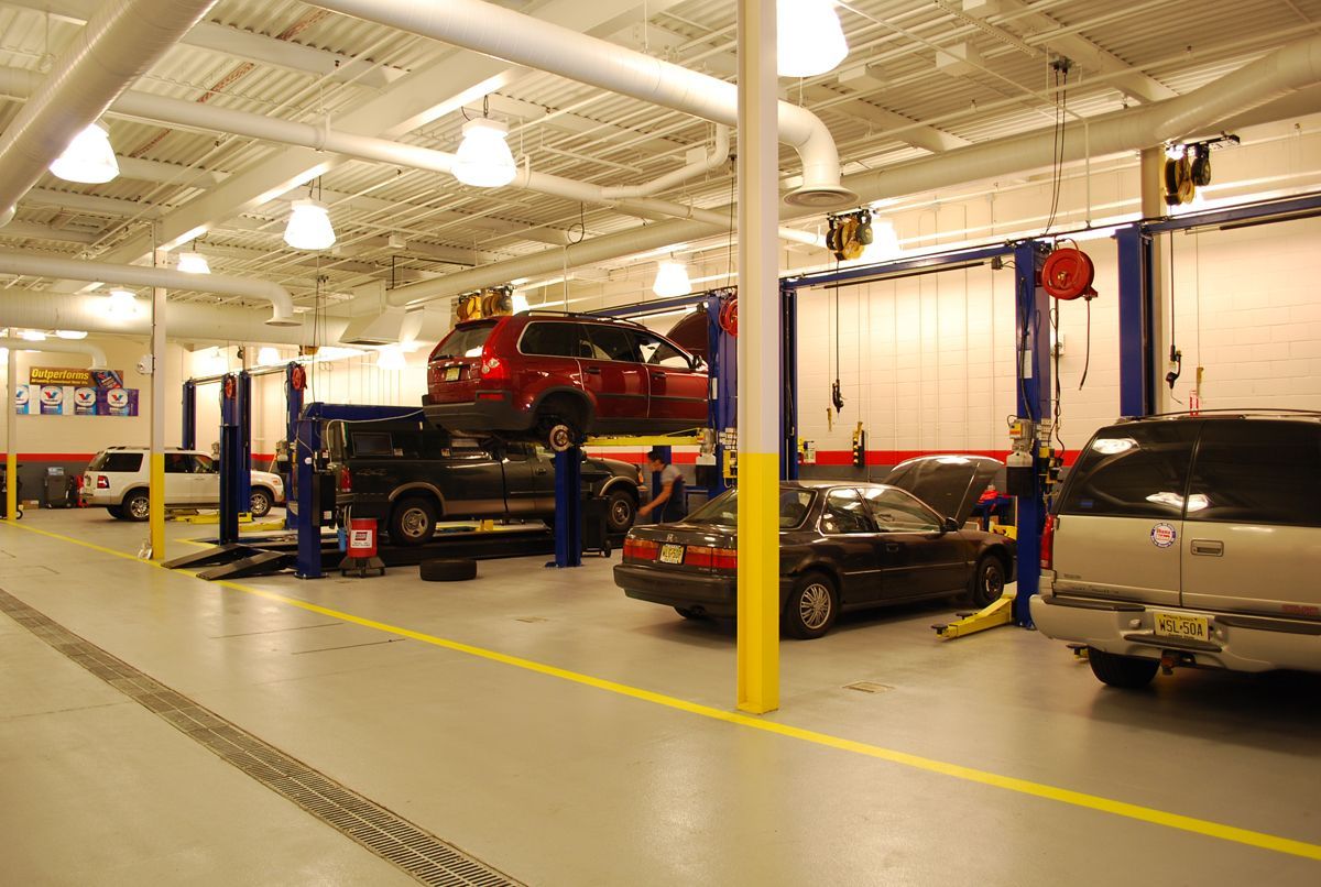 A modern, low-rise brick commercial building with a large grid-pattern glass window, red trim, and a centered entrance.
