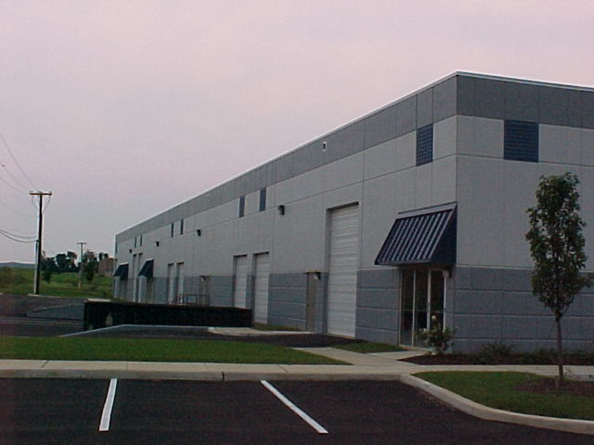 Indoor swimming pool with lanes, starting blocks, and red and black pennant flags hanging above the water.