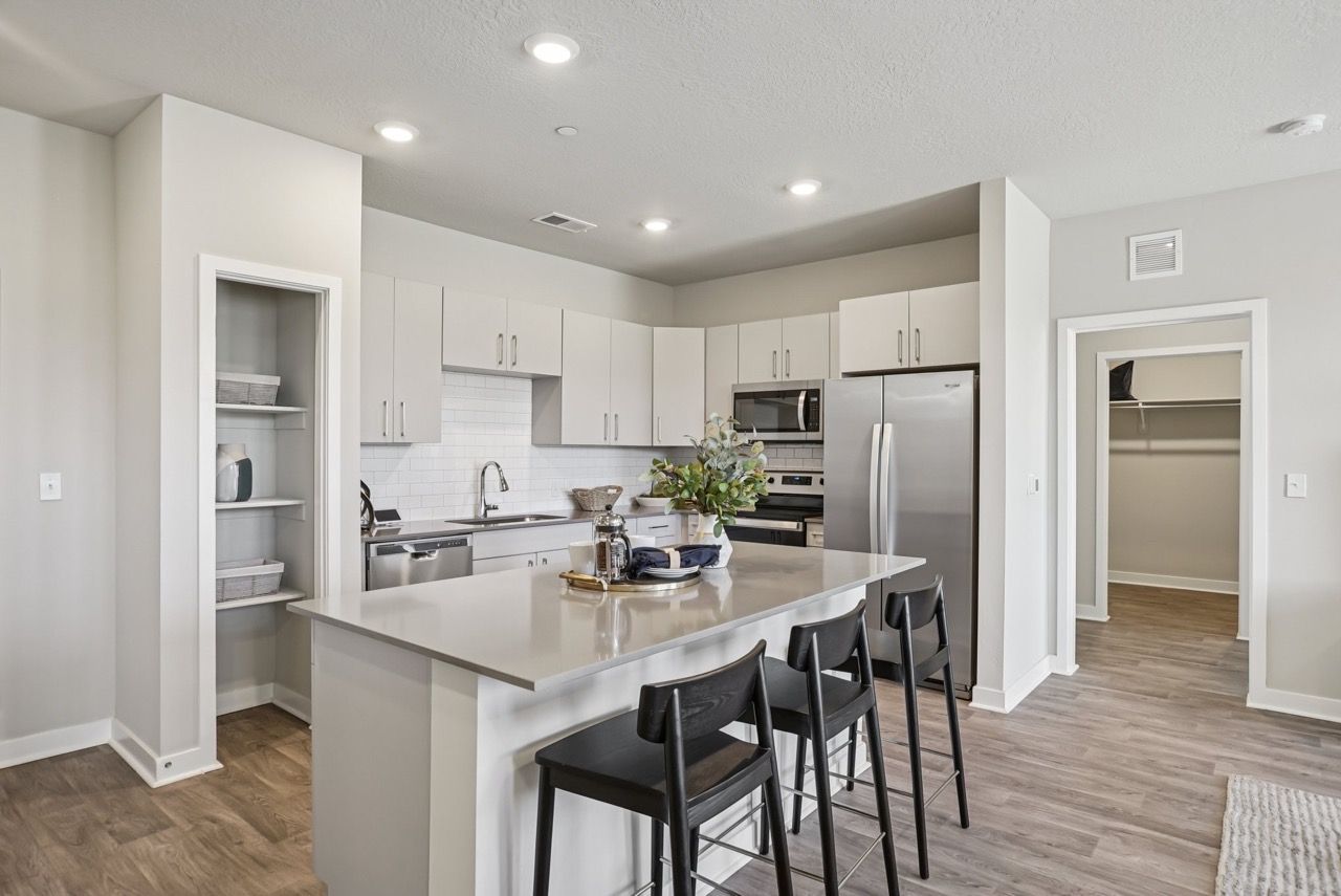 Open-concept kitchen with an island, white cabinets, and stainless-steel appliances.