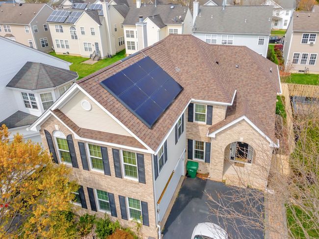 An aerial view of a house with solar panels on the roof.