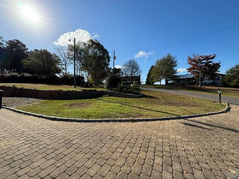 A brick driveway with a grassy area in the middle of it.