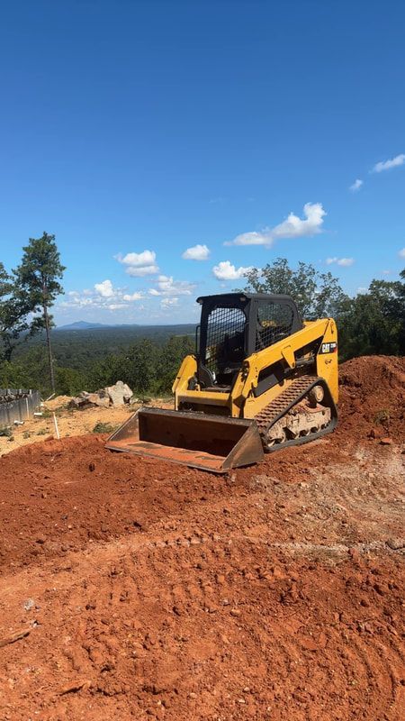 A excavation equipment is sitting on top of a dirt hill.