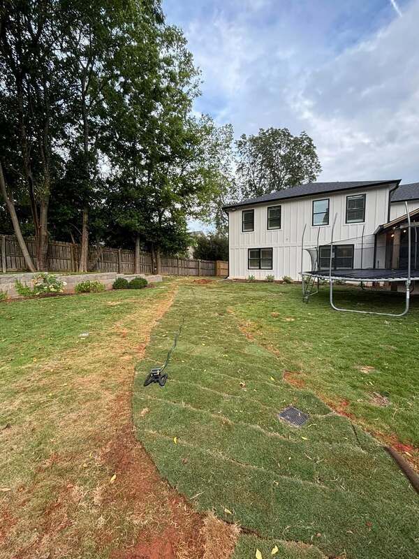 There is a trampoline in the backyard of a house.