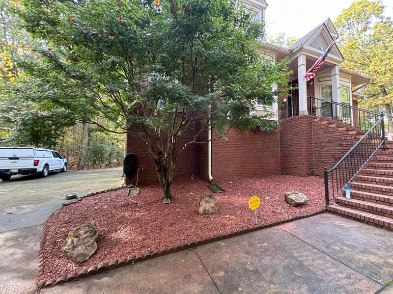 A house with stairs and a truck parked in front of it.