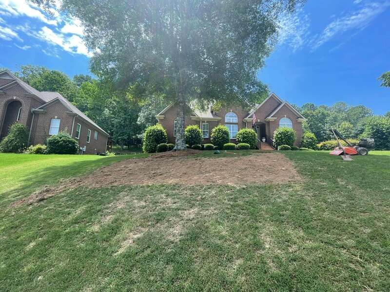 A large brick house is sitting on top of a lush green lawn.