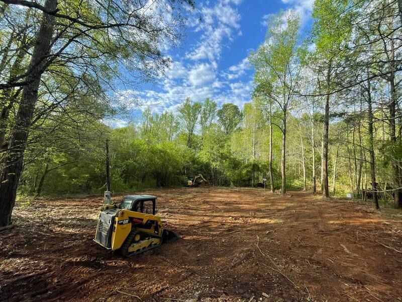 Excavation equipment is sitting in the middle of a forest.