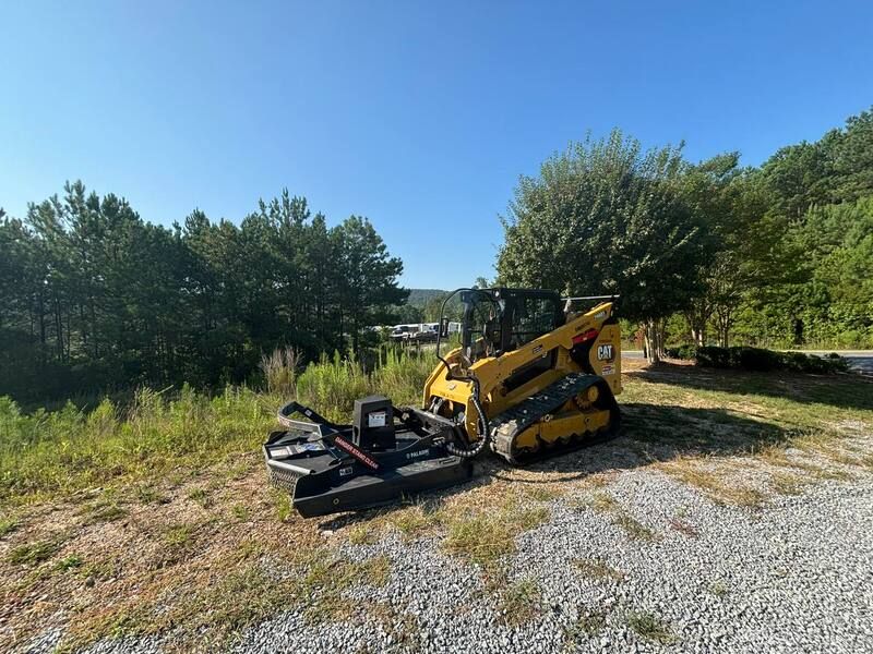 A yellow excavation equipment parked in a gravel lot.