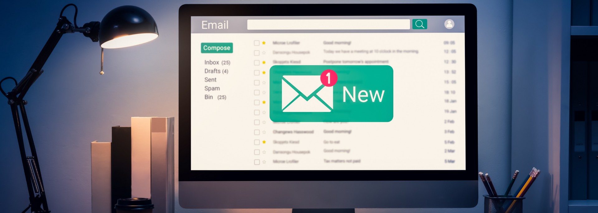 Desktop monitor showing an email inbox with a green “New” message notification on a desk at night
