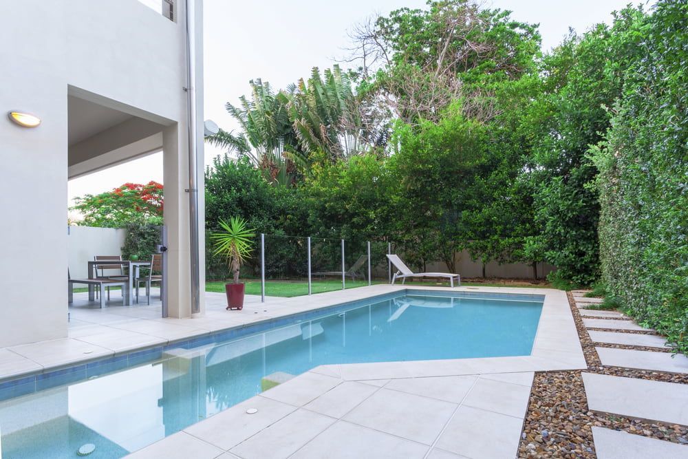 There Is A Large Swimming Pool In The Backyard Of A House — Solitary Island Pools in Coffs Harbour, NSW