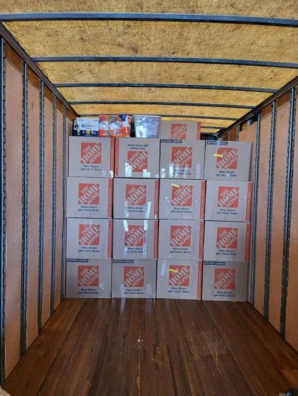 Home Depot boxes stacked inside a truck, ready for transport.