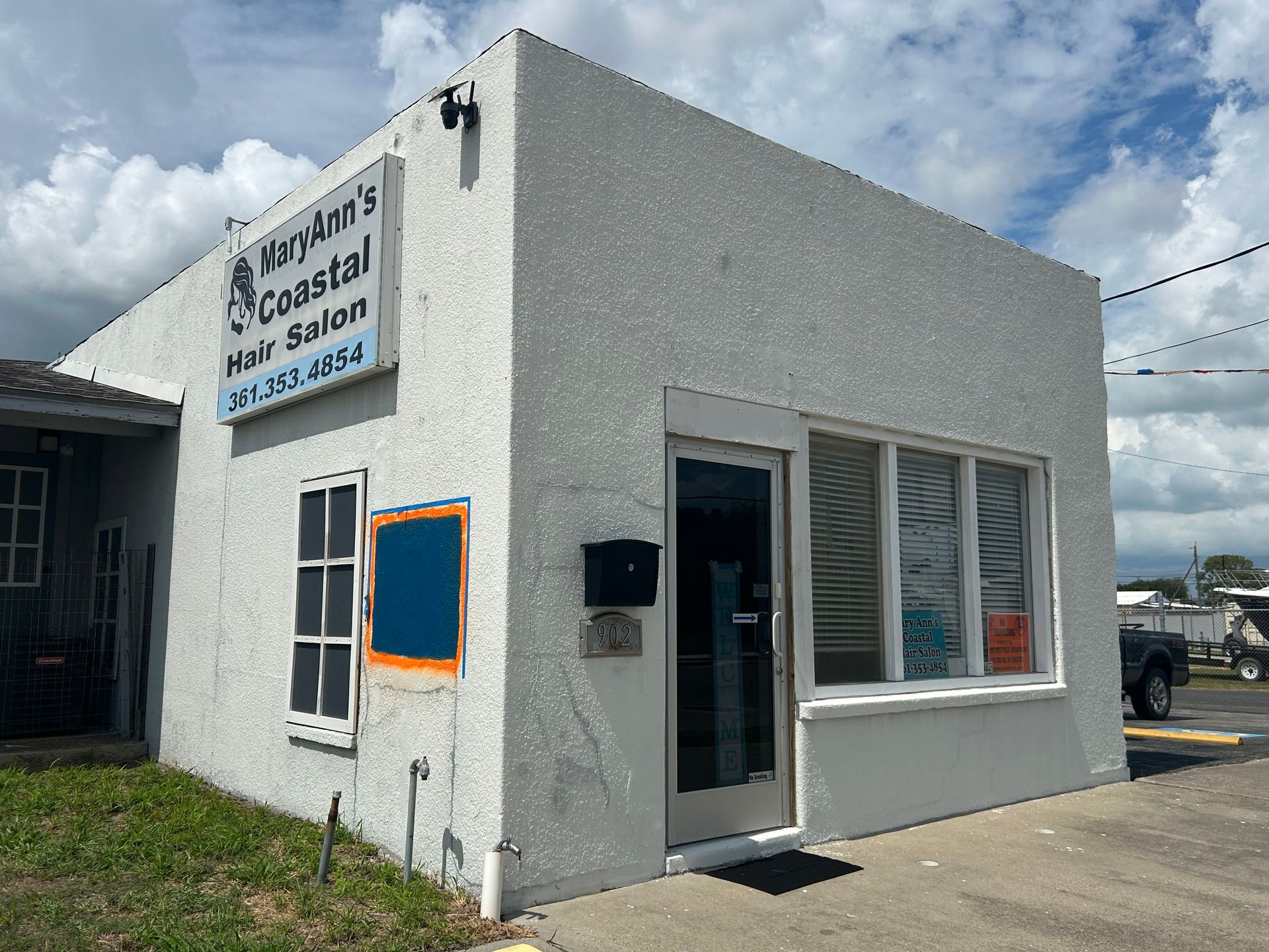 A white, single-story stucco building with a sign that reads 